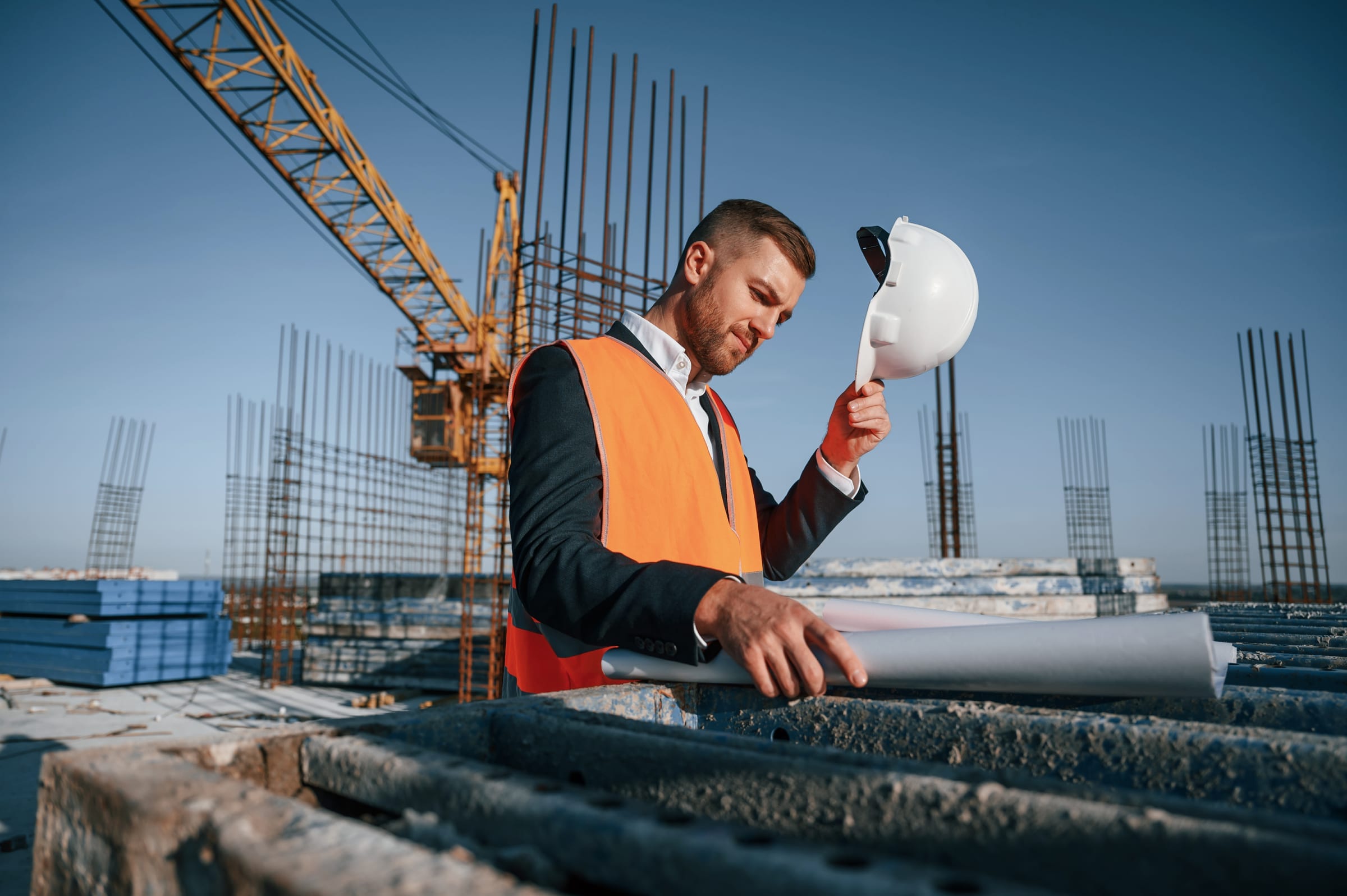 Profesional de construcción con casco y chaleco de seguridad en obra